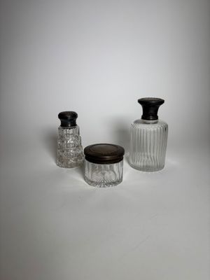 trois bocaux en verre avec leurs couvercles, posés sur une surface blanche
