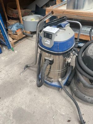 un aspirateur posé sur le sol du garage