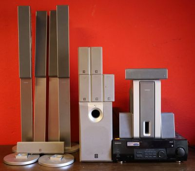 de nombreux appareils électroniques posés sur une table, avec un mur rouge en arrière-plan