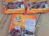 three bags of candy sitting on top of a cardboard box on a table