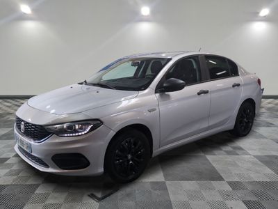 a white car is parked on a checkered floor in a garage