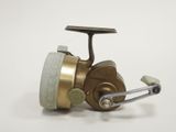 an image of a close up of a fishing reel on a white surface