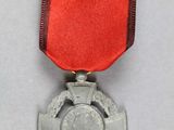 an image of a medal with a red ribbon and a cross on it