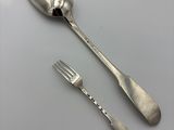 a silver spoon and a fork on a table