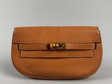 a tan leather purse with a gold clasp on the front