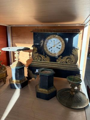 une horloge posée sur une table, à côté d'autres objets