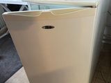a white refrigerator with a printer on top of it