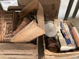 une boîte remplie de vieux livres et d'autres objets, posée par terre