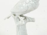 porcelain figurine of a bird perched on a tree stump