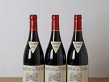 trois bouteilles de vin posées sur une table en bois