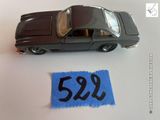 une petite voiture posée à côté d'un morceau de feutrine