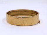 a close up of a gold ring on a white surface