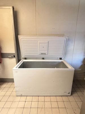 a white chest freezer sitting in the corner of a room