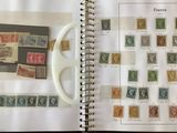 an open book with stamps and a cup of coffee on a table