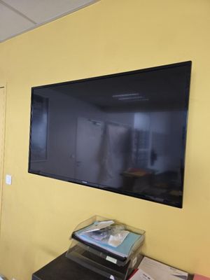 un téléviseur à écran plat fixé au mur d'une pièce