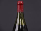 bottle of red wine on a black table with a dark background