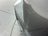 a close up of a car ' s front bumper on the side of the road