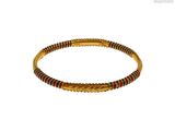 un gros plan sur un bracelet en or orné de perles rouges et vertes