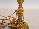 a gold colored candle holder with a rope around it