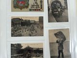 an old photo of a man holding an umbrella standing in front of a bunch of postcards