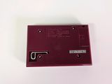 a close up of a red electronic device on a white surface