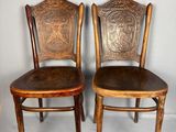 paire de chaises anciennes en bois avec des assises rembourrées de cuir