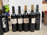 several bottles of wine are lined up in a row on a counter