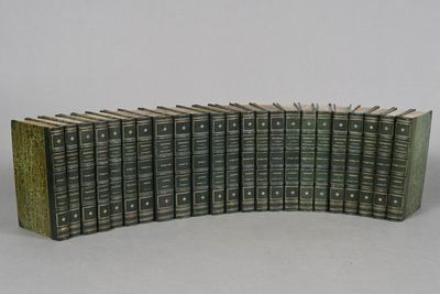 many books stacked on top of each other on a table