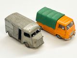 deux camions miniatures posés l'un à côté de l'autre sur une surface blanche