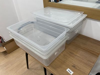 two plastic containers sitting on top of a wooden table