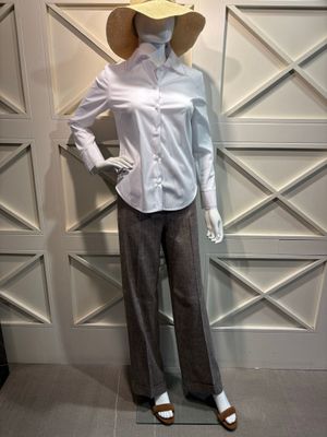 un mannequin vêtu d'une chemise blanche et d'un pantalon marron