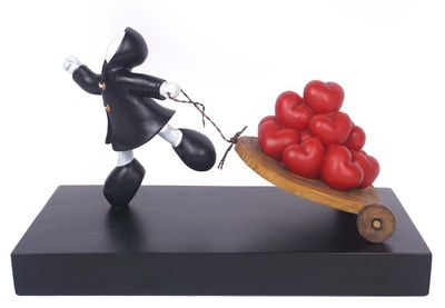 statue of a man pulling a wheelbarrow with tomatoes on it