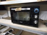 un micro-ondes posé sur une étagère, avec une étiquette de prix dessus