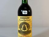 une vieille bouteille de vin posée sur une table blanche