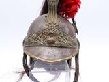 un vieux casque surmonté d'une plume rouge