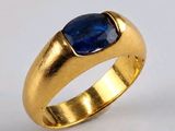 gros plan d'une bague en or avec une pierre bleue