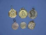 quatre médailles d'argent de tailles et de formes variées sur fond bleu