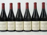 six bouteilles de vin sont alignées sur une table