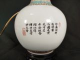 a white vase with chinese writing on it sitting on a table