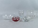 three glass pitchers and a pitcher on a white surface