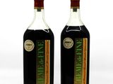 two bottles of olive oil sitting next to each other on a white surface