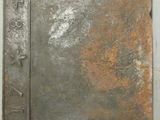 une porte métallique rouillée fixée au mur d'un immeuble