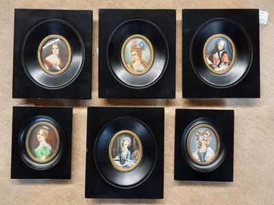 Quatre photos encadrées représentant des femmes en tenue de cérémonie sont accrochées au mur.