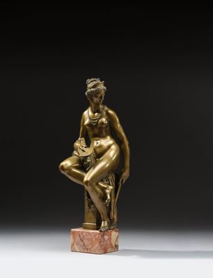 une statue en bronze représentant une femme assise sur un bloc de marbre