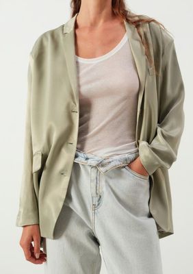une photo d'une femme portant une veste verte et un jean