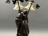 a statue of a woman holding a flower in a vase
