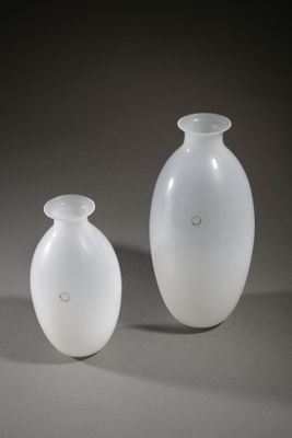 two white vases sitting next to each other on a table