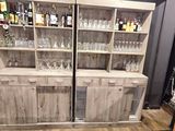 une grande armoire en bois sur laquelle sont posés des verres à vin