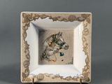 an image of a white and gold plate with a picture of a horse on it