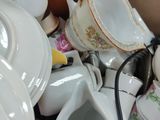 a pile of tea cups and saucers in a box